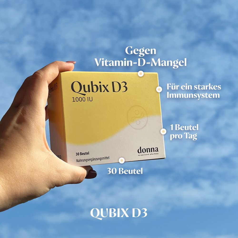 Hand hält Qubix D3-Packung. Text: Gegen Vitamin-D-Mangel, Für ein starkes Immunsystem, 1 Beutel pro Tag, 30 Beutel, Qubix D3, donna.