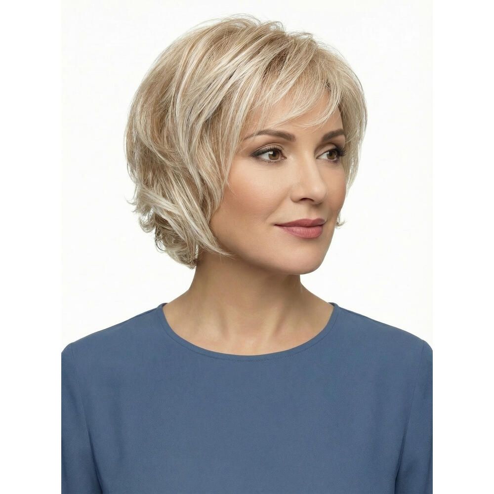 Blonde Perücke mit kurzem, gewelltem Schnitt. Dreiviertelansicht einer Frau mit blauem Oberteil.