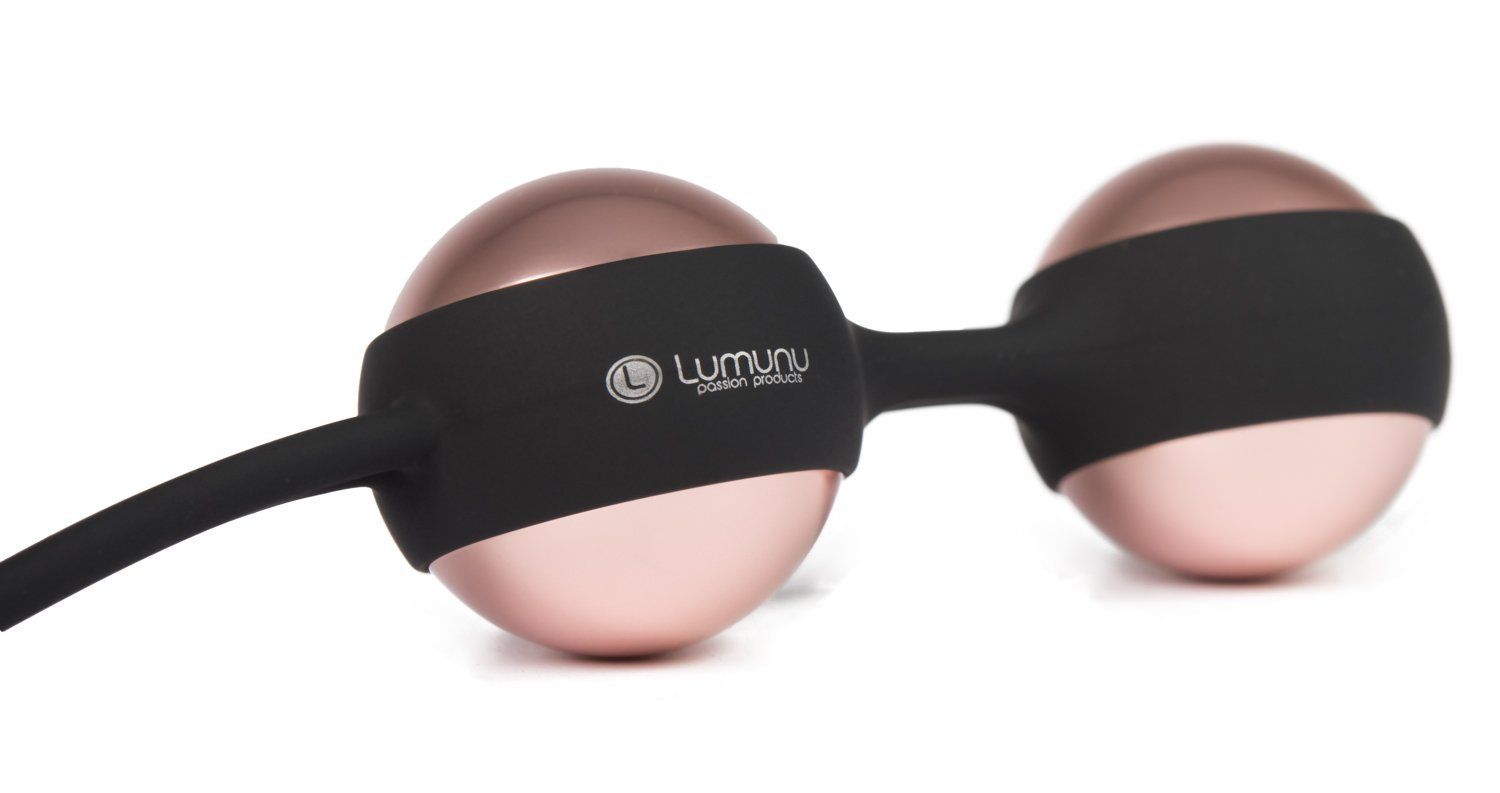 Zwei roségoldene Kugeln, verbunden durch einen schwarzen Steg. Auf dem Steg steht "Lumunu passion products".