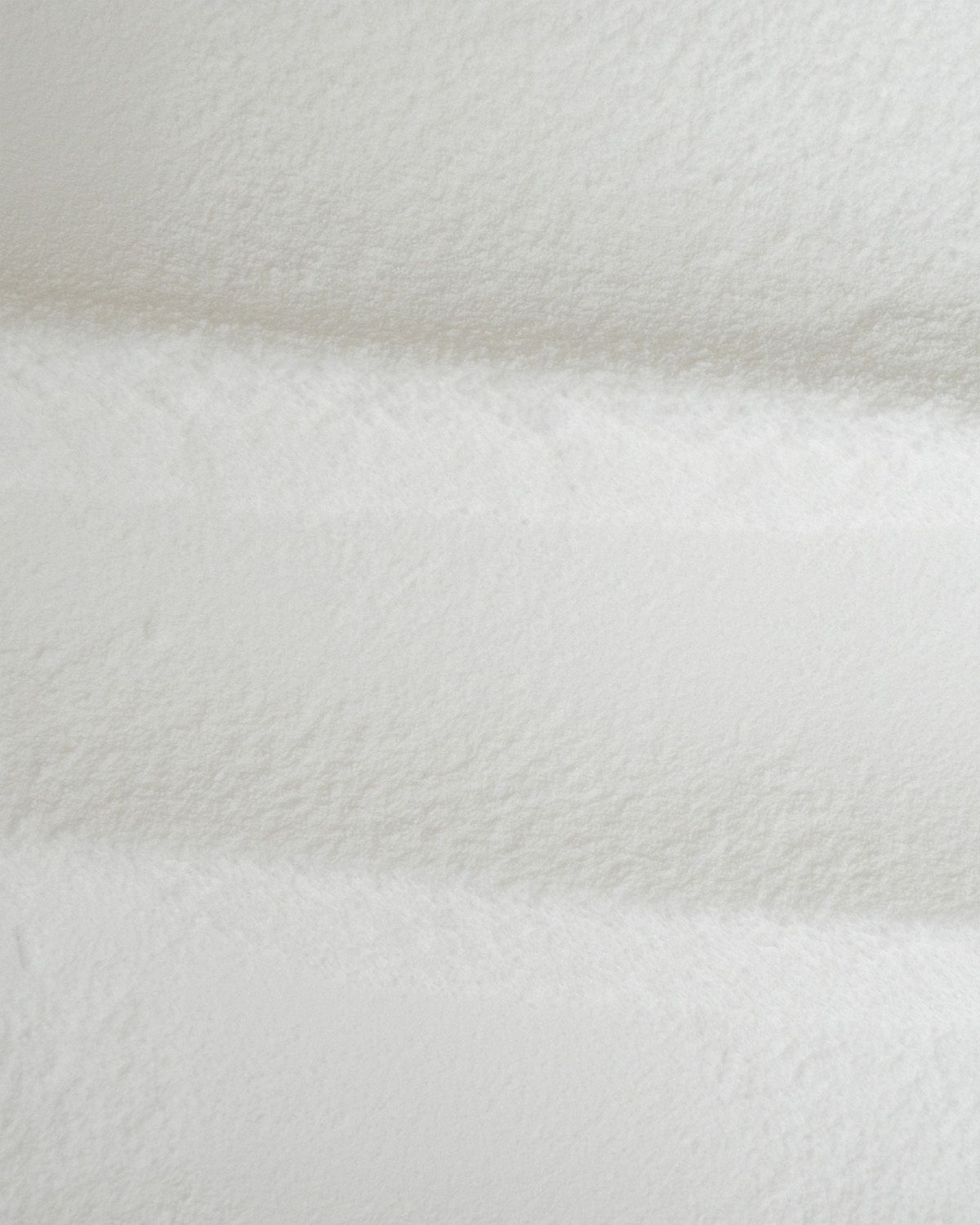 Textur von feinem weißem Maltodextrin Pulver mit Wellenmuster.