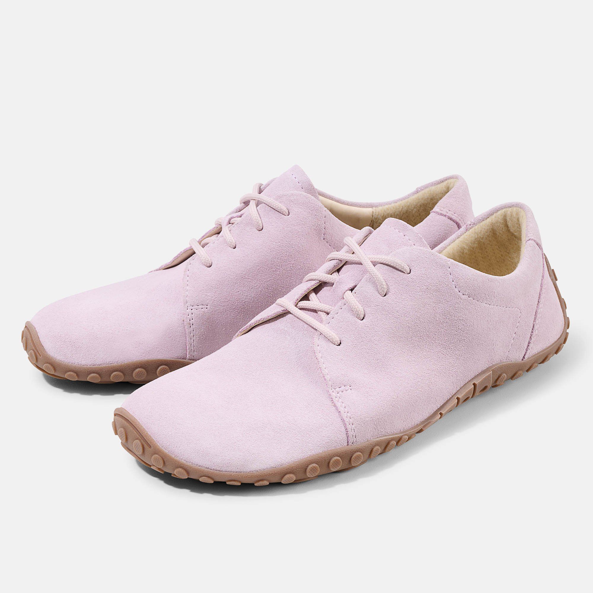 Zwei hellrosa Schnürschuhe. Braune Sohle mit Noppen. Hellrosa Schnürsenkel. Aus Wildleder.