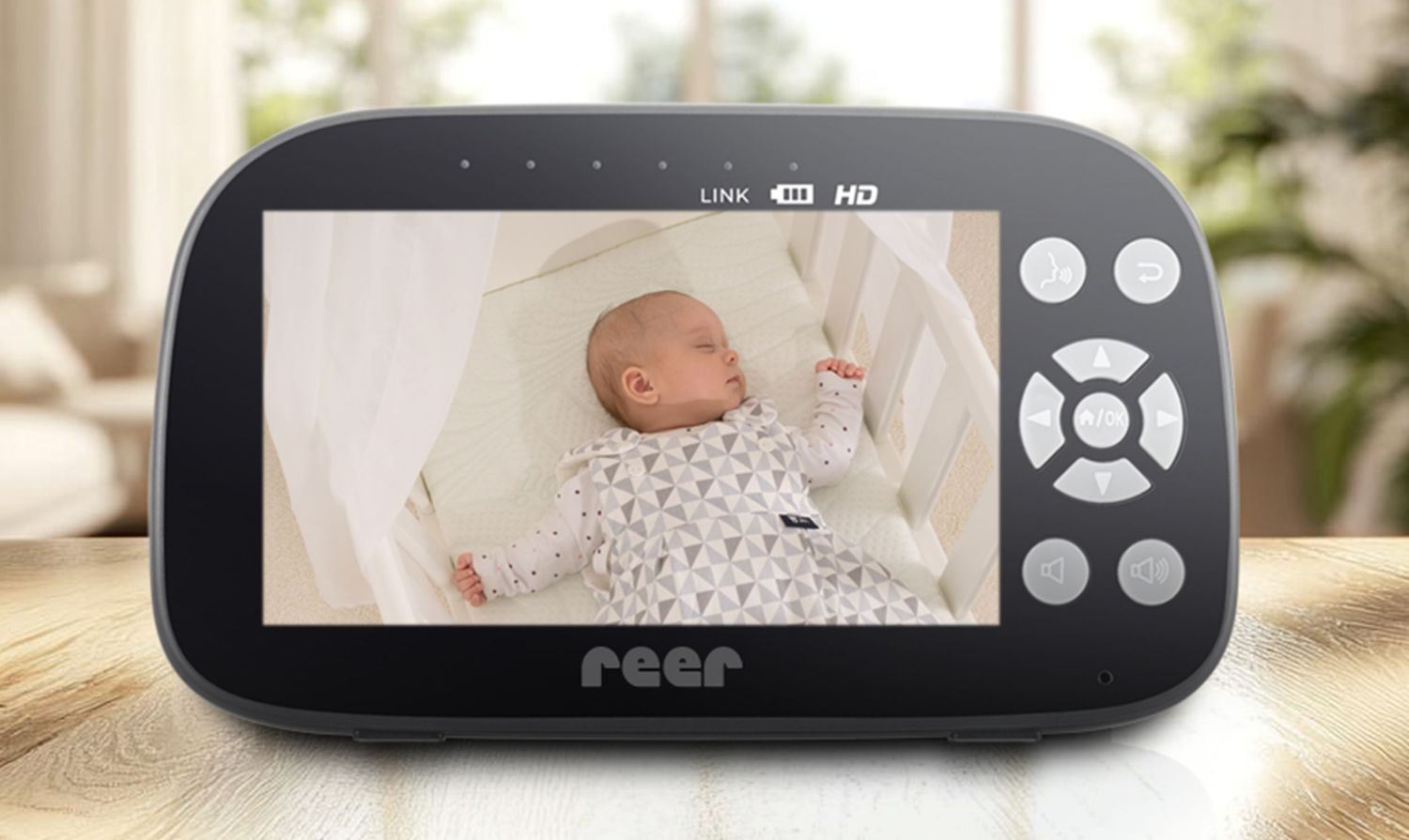 Babyphone-Kamera an Wand montiert über Babybett, zeigt schlafendes Baby.