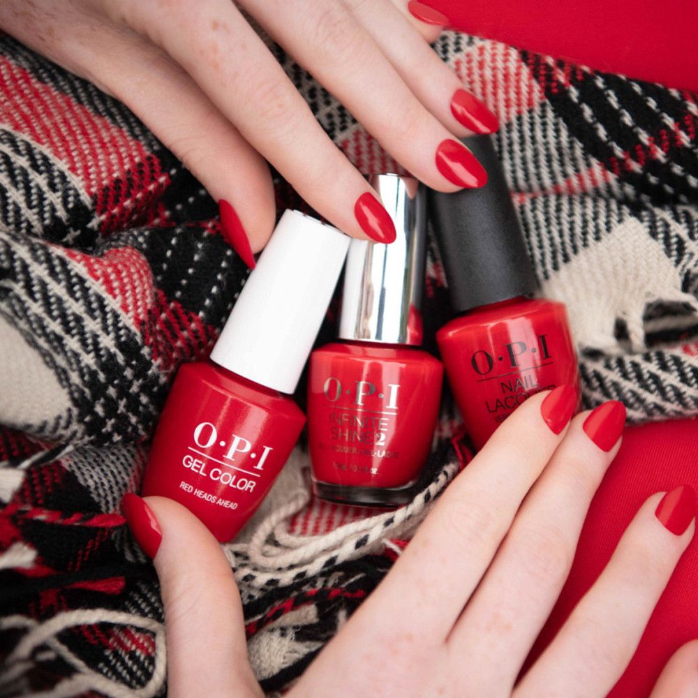 Drei rote Nagellackflaschen, darunter OPI Gel Color. Hände mit lackierten Nägeln.