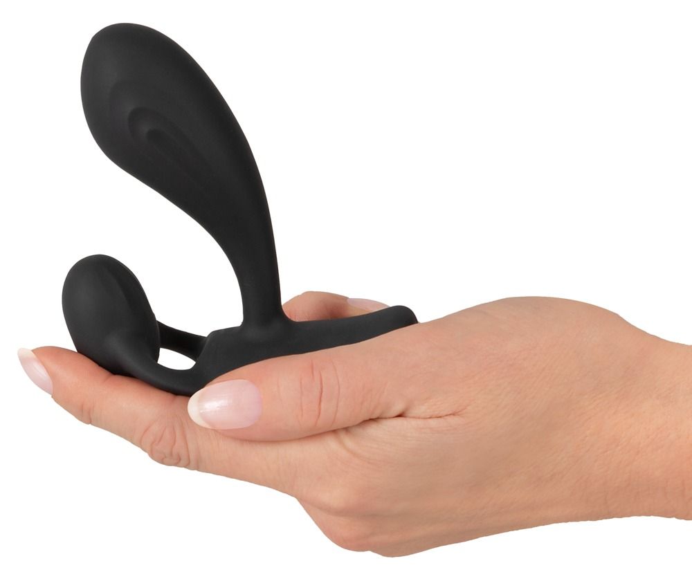 Schwarzes Wellness-Produkt in einer Hand gehalten. Es hat zwei abgerundete Enden und einen länglichen, gebogenen Teil.