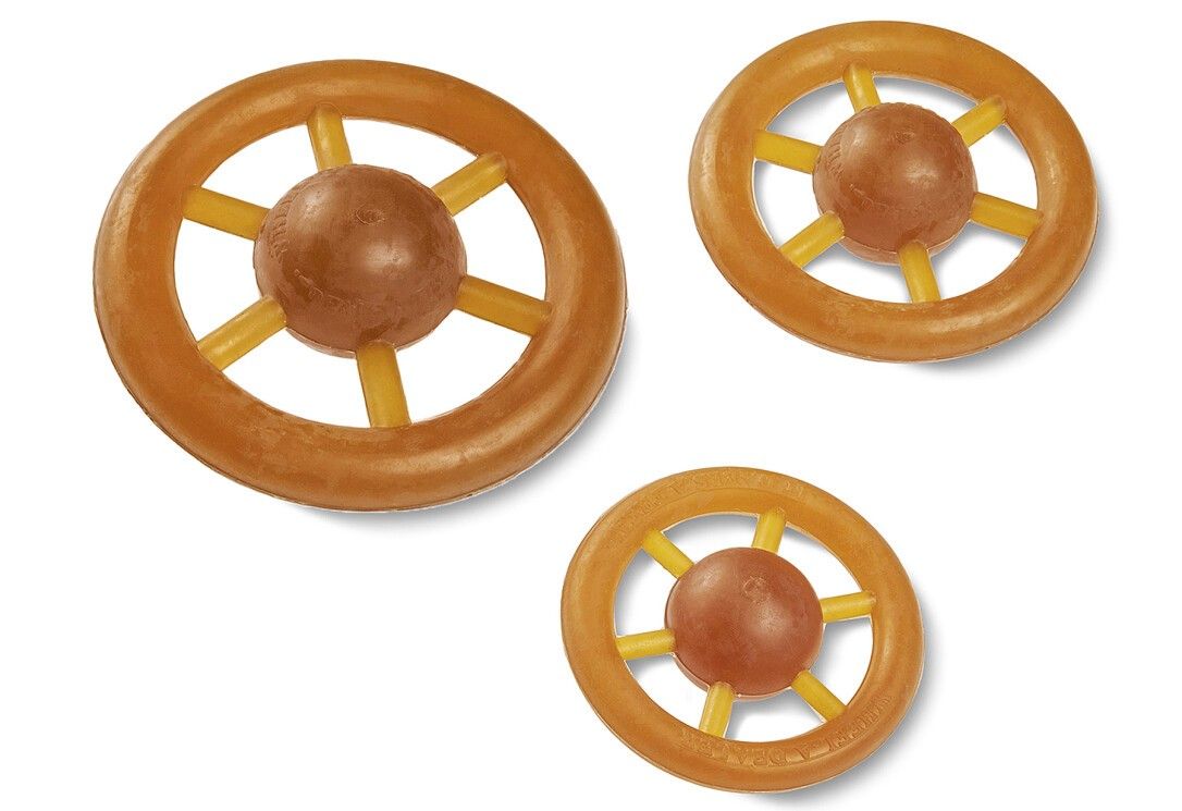 Drei Spielzeugräder mit Speichen und zentralen Bällen. Gelb-braune Farbtöne. Naturmaterial.