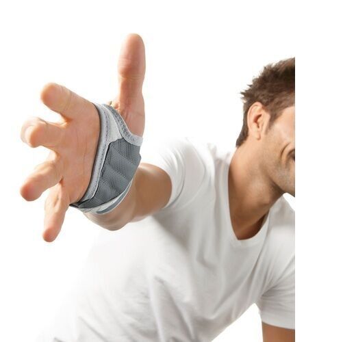 Handgelenkbandage am Handrücken einer Person. Grau-weiß, offenes Design. Person streckt Hand aus.