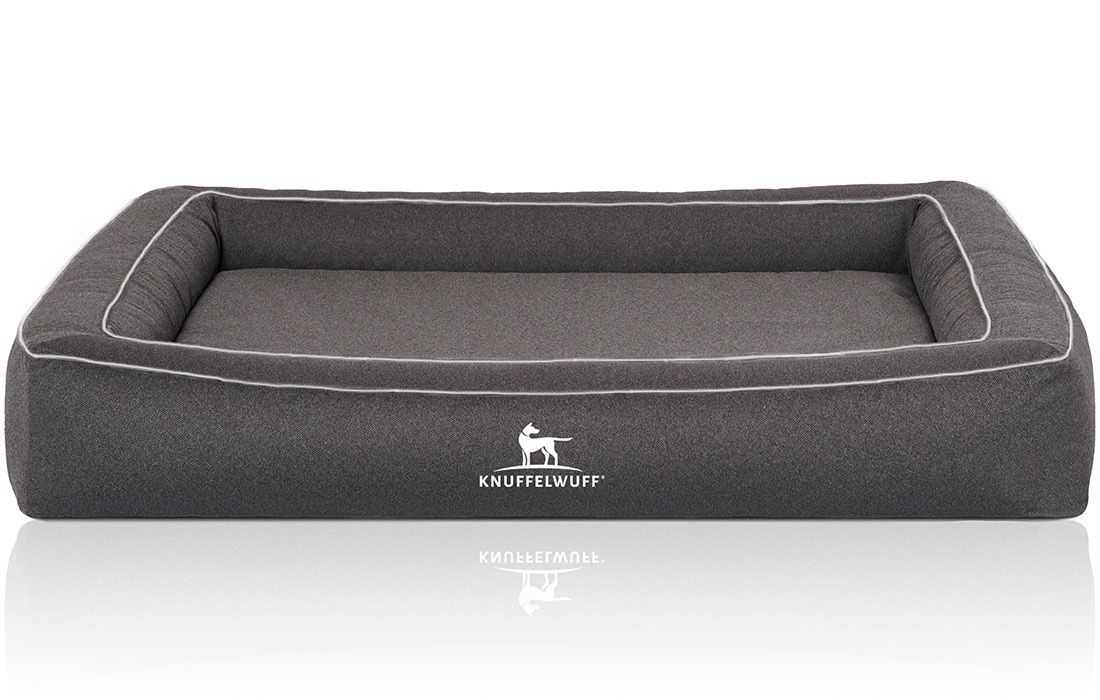 Graues Hundebett mit weißem Rand. Das Logo "Knuffelwuff" ist auf der Vorderseite sichtbar.