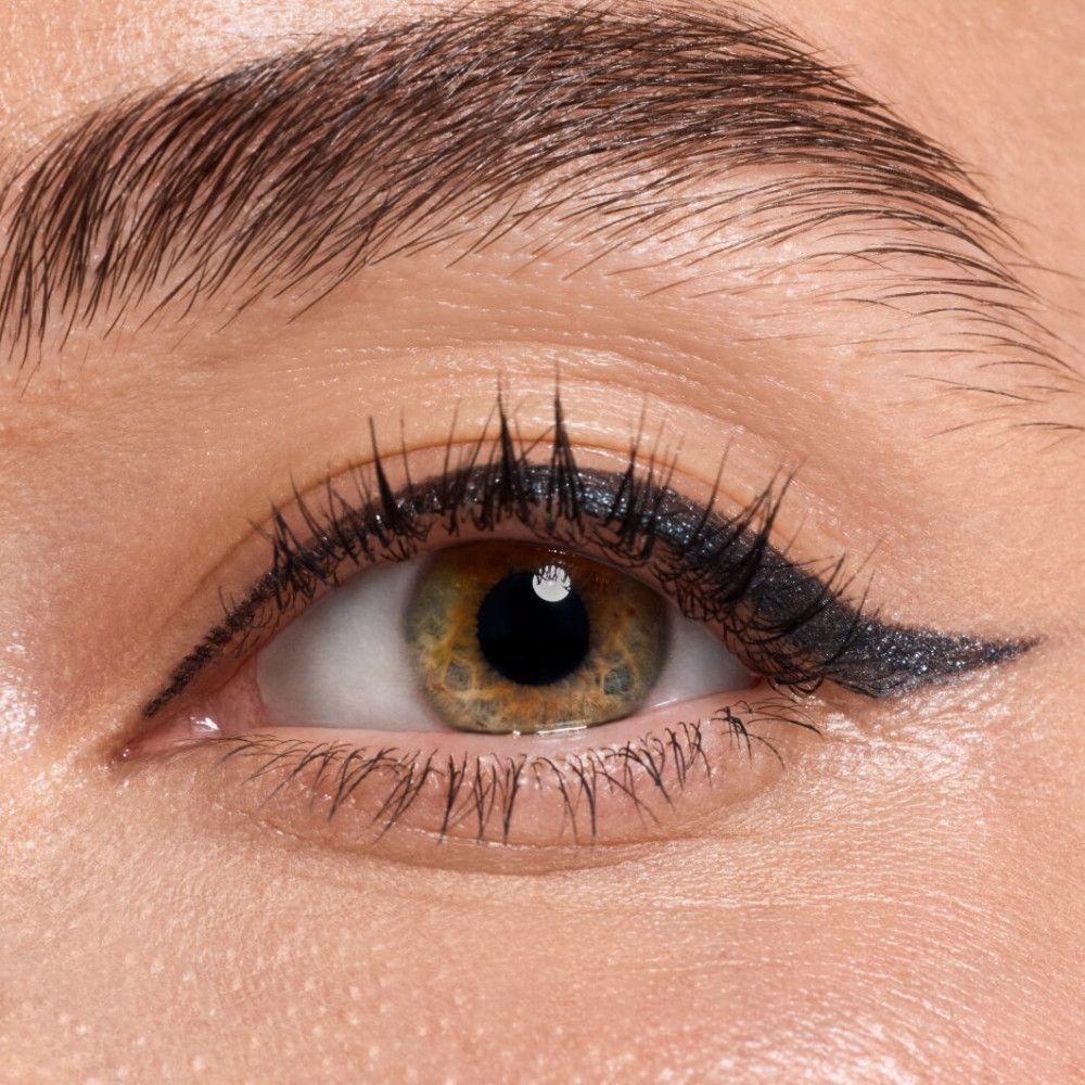 Nahaufnahme eines Auges mit schwarzem Lidstrich. Grüne Augenfarbe.