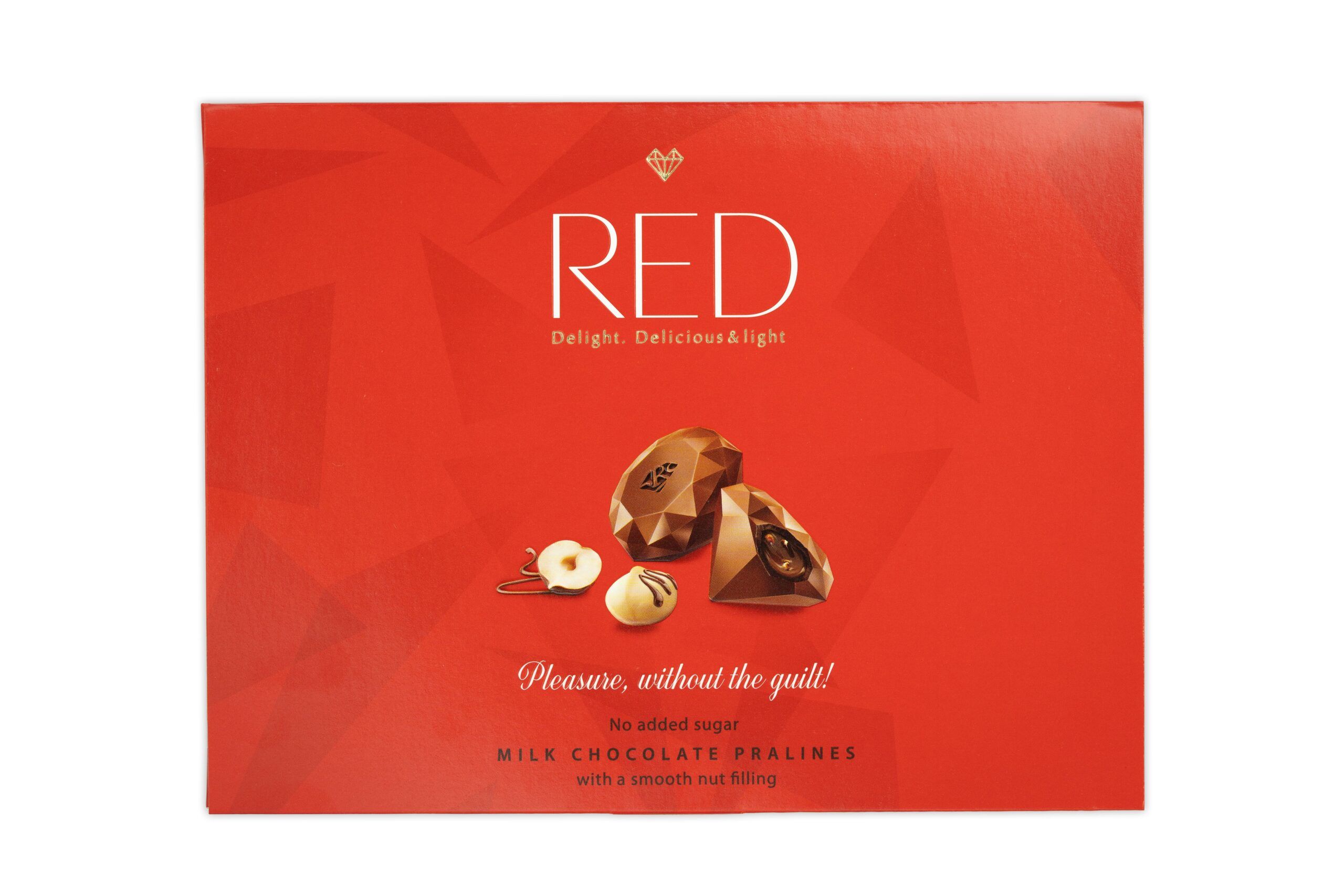 Rote Schachtel mit Pralinen. Aufschrift "RED". Abgebildet sind Pralinen und Haselnüsse. Text: "Pleasure, without the guilt!" und "Milk Chocolate Pralines".