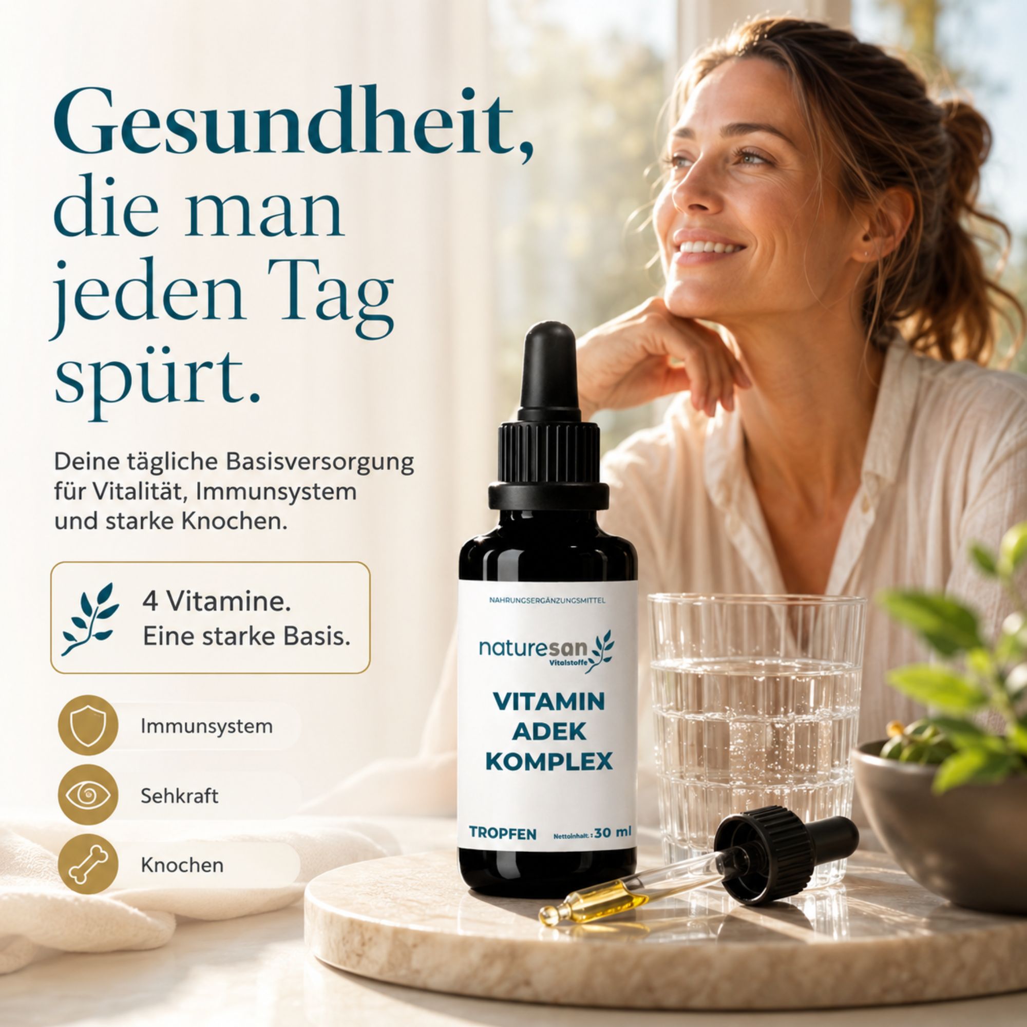 Naturesan Vitamin ADEK Komplex Tropfen 30ml in dunkler Glasflasche neben einem Glas Wasser.