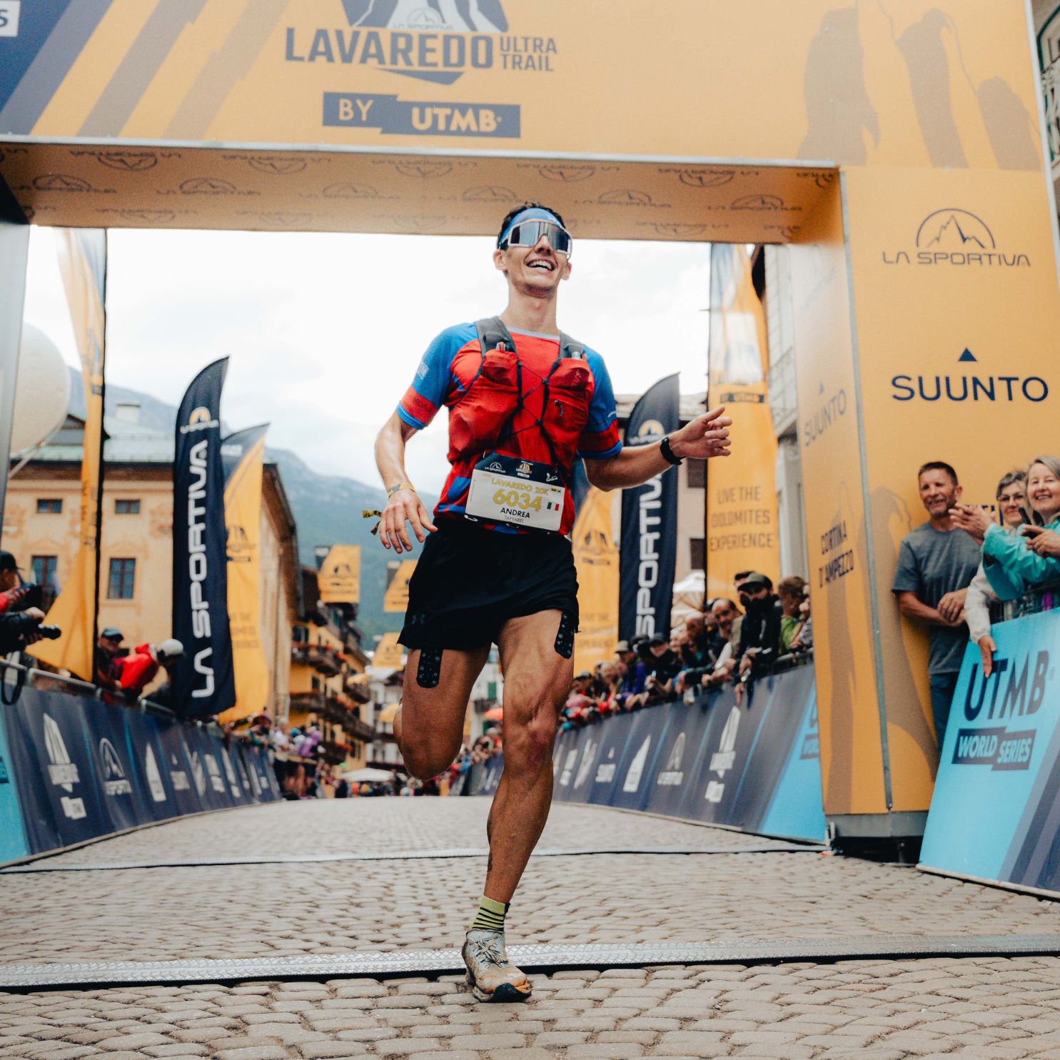 Läufer im Ziel, trägt Sportpflaster. Hintergrund: Lavaredo Ultra Trail, La Sportiva, Suunto.