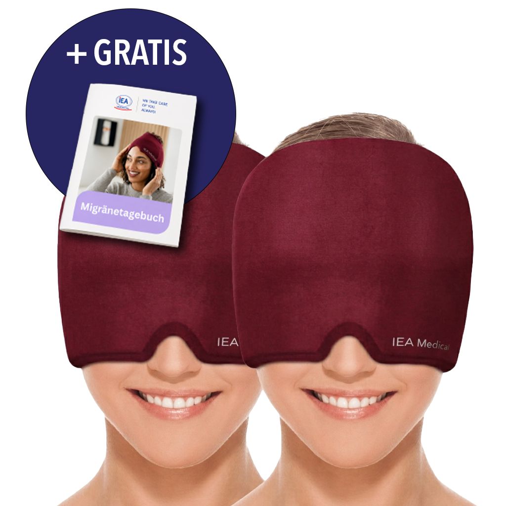 Zwei dunkelrote IEA Medical Migränemasken, eine davon mit einem "+ GRATIS" Aufkleber auf einem Migränetagebuch.