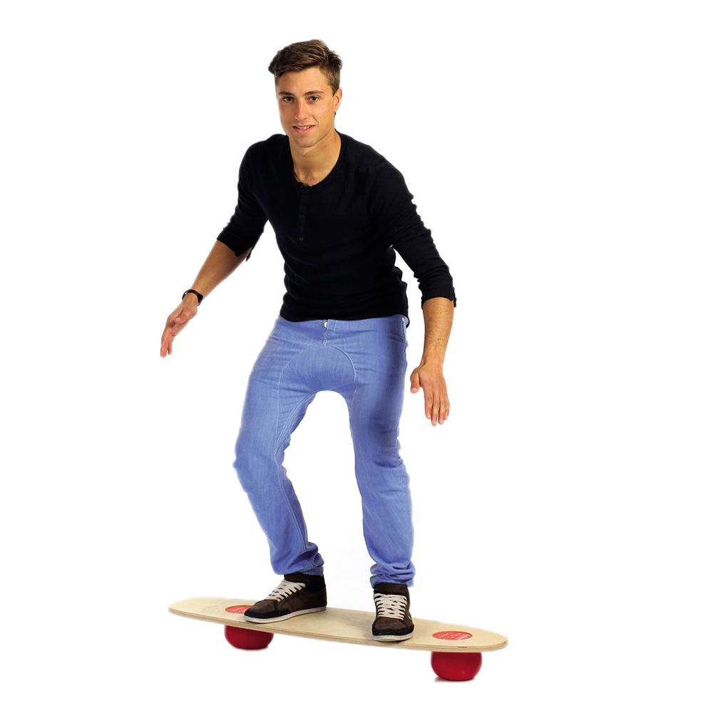 Mann auf Togu Balanza® Freeride. Holzbrett mit roten Kugeln. Steht auf dem Brett, weißer Hintergrund.