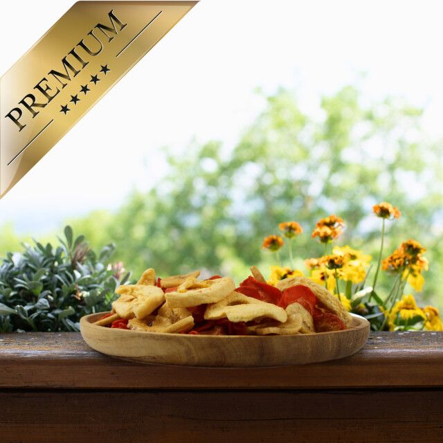 Getrocknete Obst- und Gemüsestücke in einer Holzschale. Goldener Aufkleber mit 'PREMIUM' und Sternen.