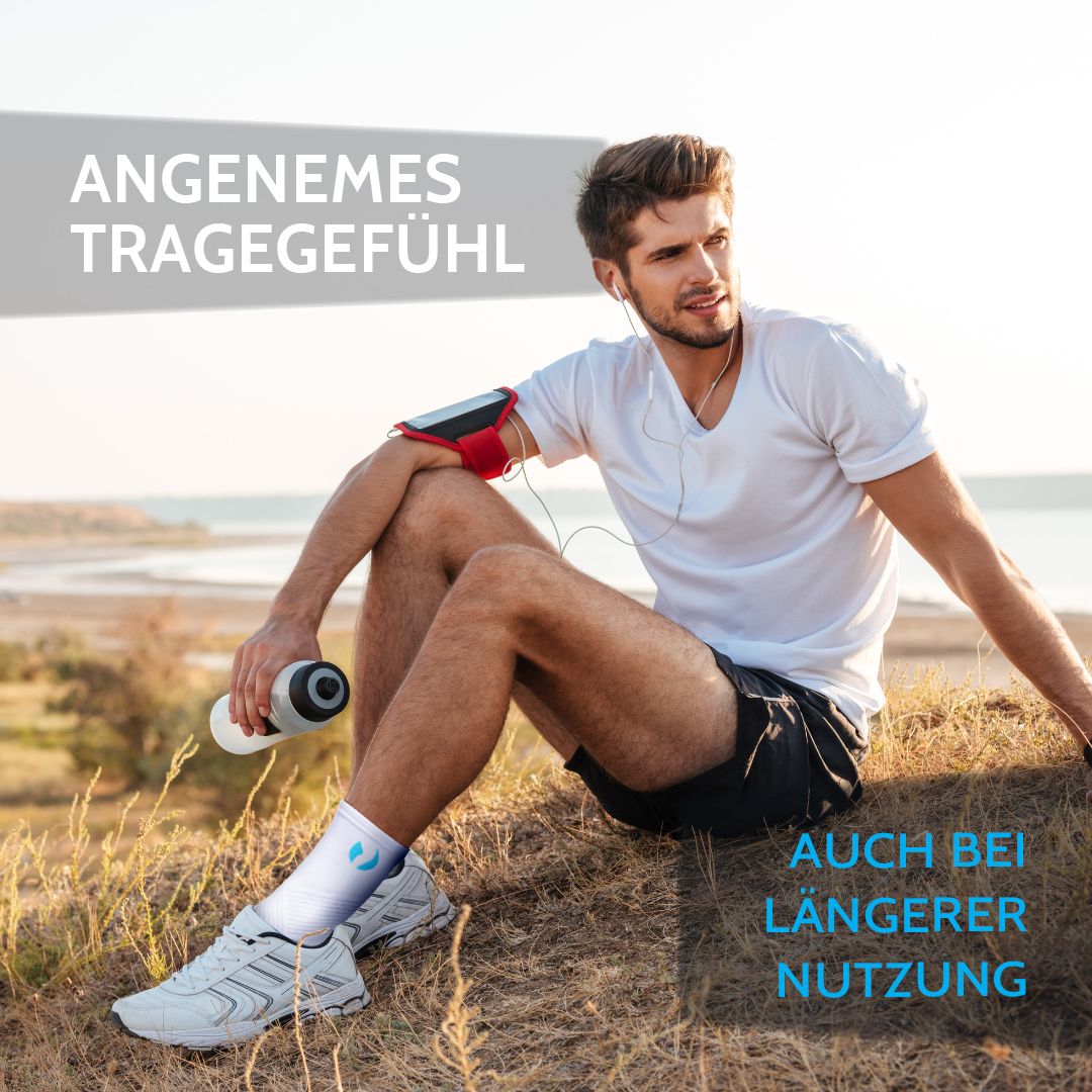 Mann sitzt am Strand, trägt weisse Sprunggelenkbandage. Text: Angenehmes Tragegefühl. Auch bei längerer Nutzung.