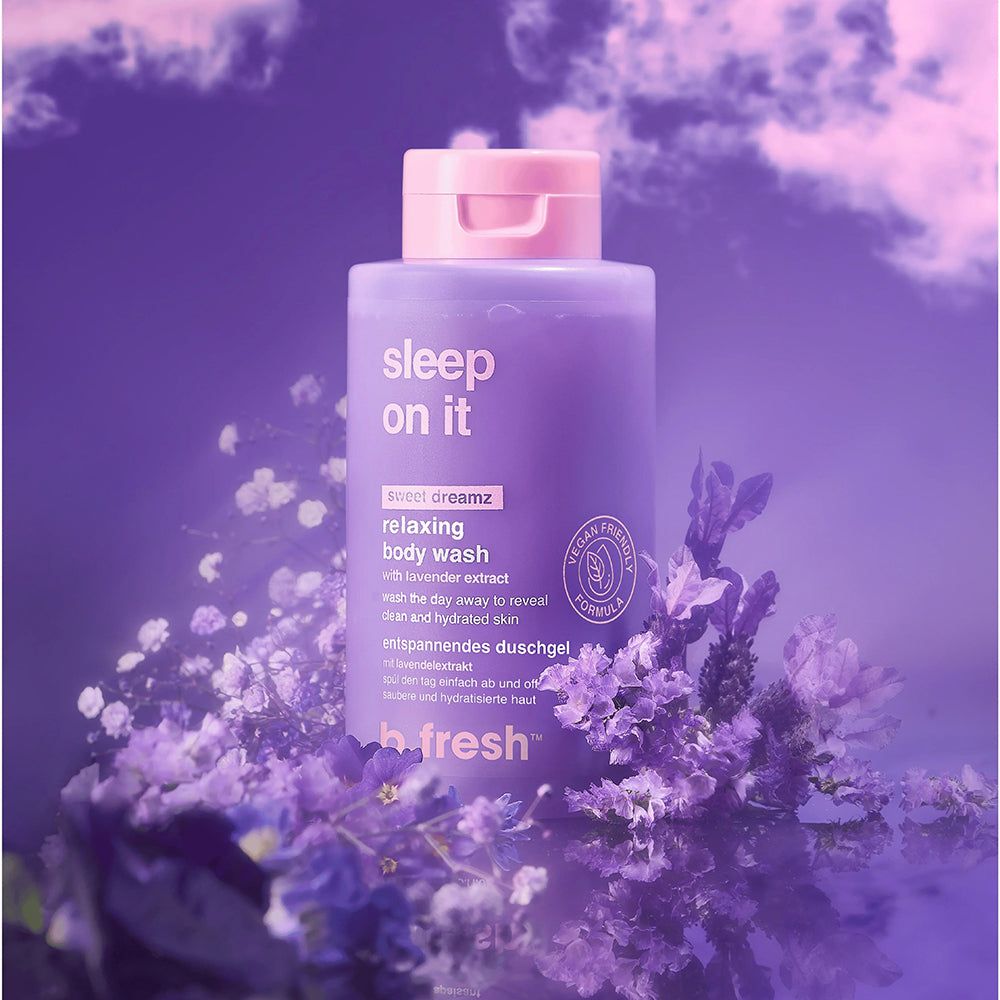 Entspannendes Körperwaschmittel in einer lila Flasche mit rosa Verschluss, umgeben von Lavendel.