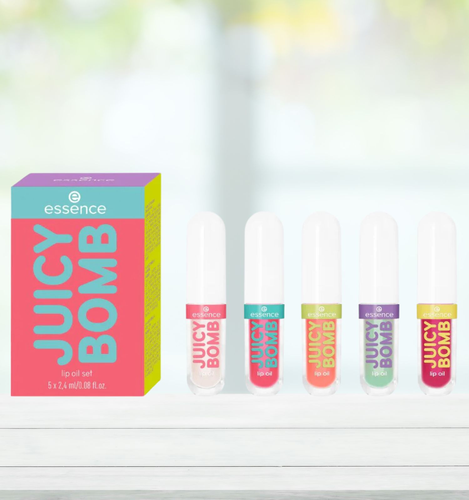 Lipolie set met verpakking en 4 lipoliën. Op de verpakking staat "essence JUICY BOMB lip oil set".