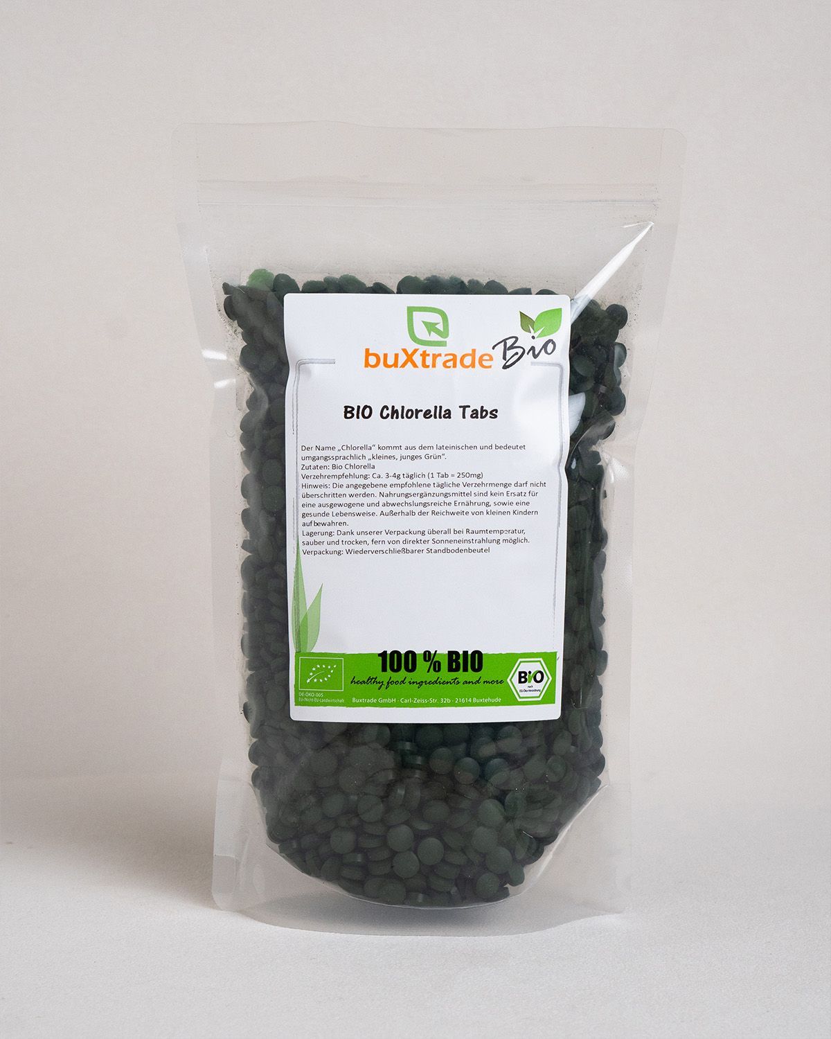 Transparente Tüte mit grünen Tabletten. Auf der Verpackung steht 'buXtrade Bio Chlorella Tabs' und ein Bio-Siegel.