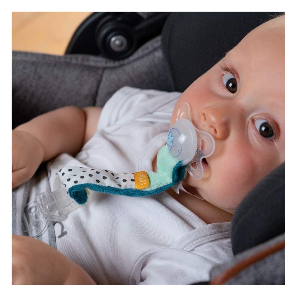 Baby mit Schnuller und Schnullerkette Minze. Baby im Autositz. Schnuller im Mund.