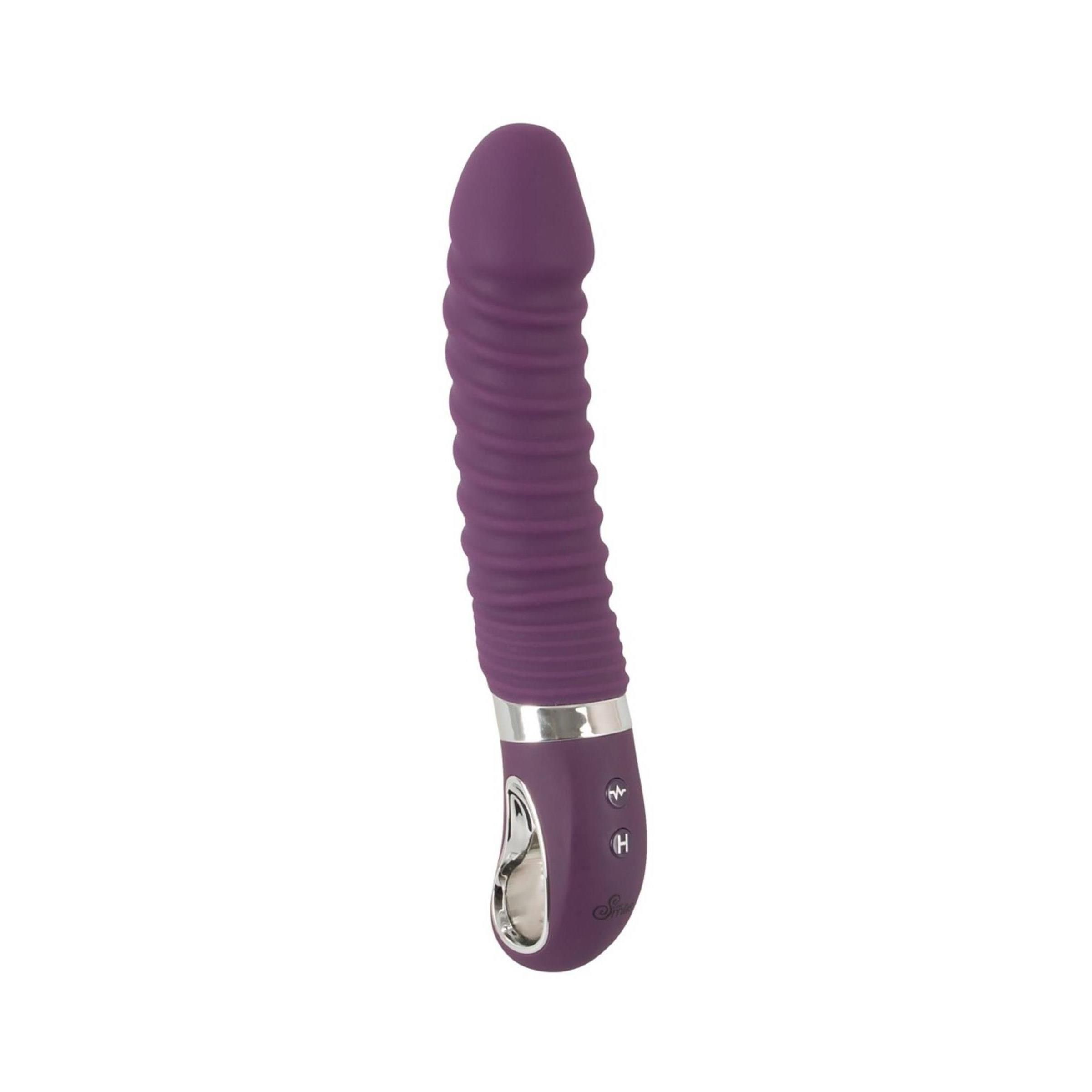 Lila Vibrator mit geriffelter Oberfläche. Silberfarbener Ring am unteren Ende. Bedienfeld mit Knöpfen. Abgerundete Spitze.