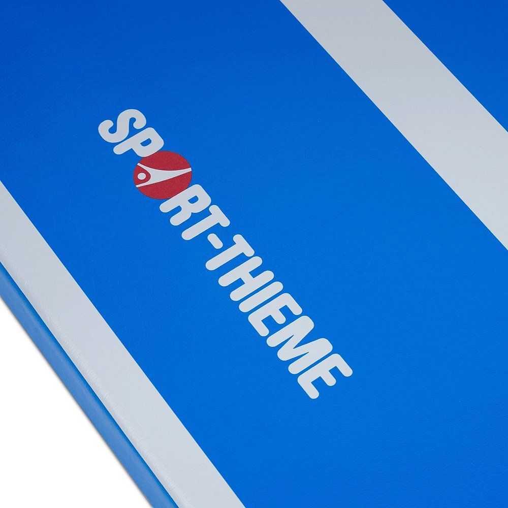 Blaue Turnmatte mit weißem Streifenmuster und Sport-Thieme Logo. Nahaufnahme, diagonale Ansicht.