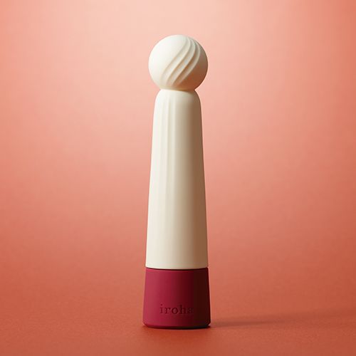 Weiß-roter Vibrator mit kugelförmigem Kopf und geriffelter Oberfläche. Roter Hintergrund.