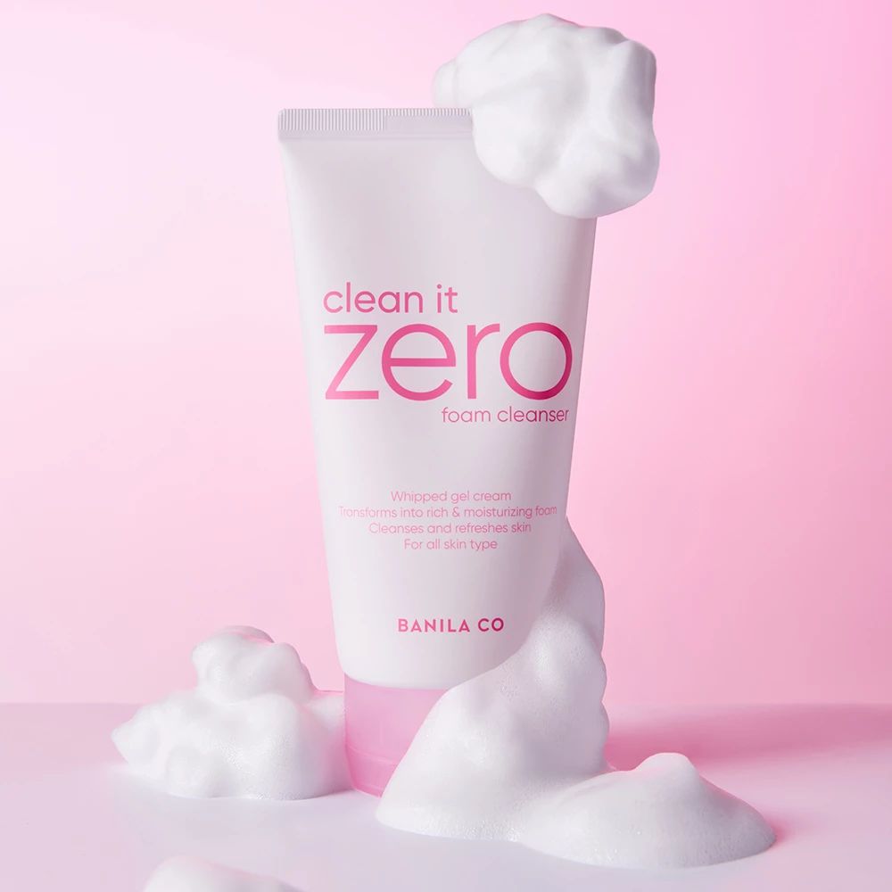 Weiße Tube mit rosa Deckel, umgeben von Schaum. Aufschrift "clean it zero foam cleanser" und "BANILA CO".