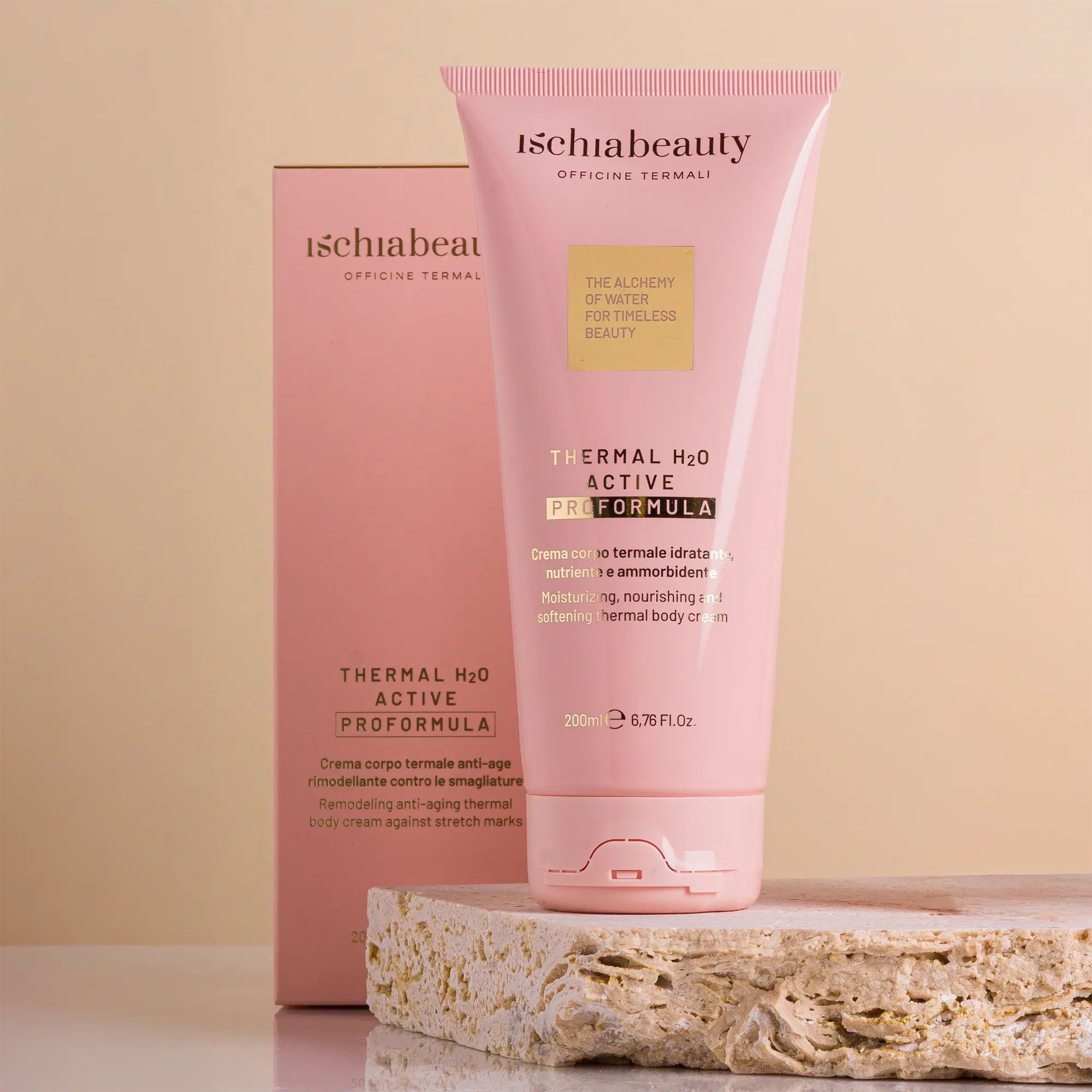 Rosa Tube und Schachtel mit Produkttext. Aufschrift: ischiabeauty, Thermal H2O Active Pro Formula. Auf Stein platziert.