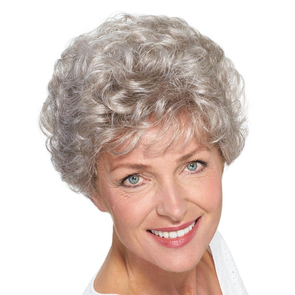 Graue Perücke mit lockigem Haar. Die Frau lächelt in die Kamera. Nahaufnahme.
