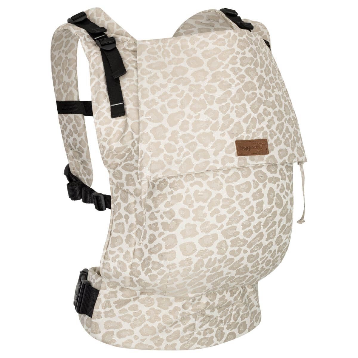 Babytrage mit beige-grauem Fleckenmuster. Schwarze Schnallen und Träger. Kleines Markenlabel.