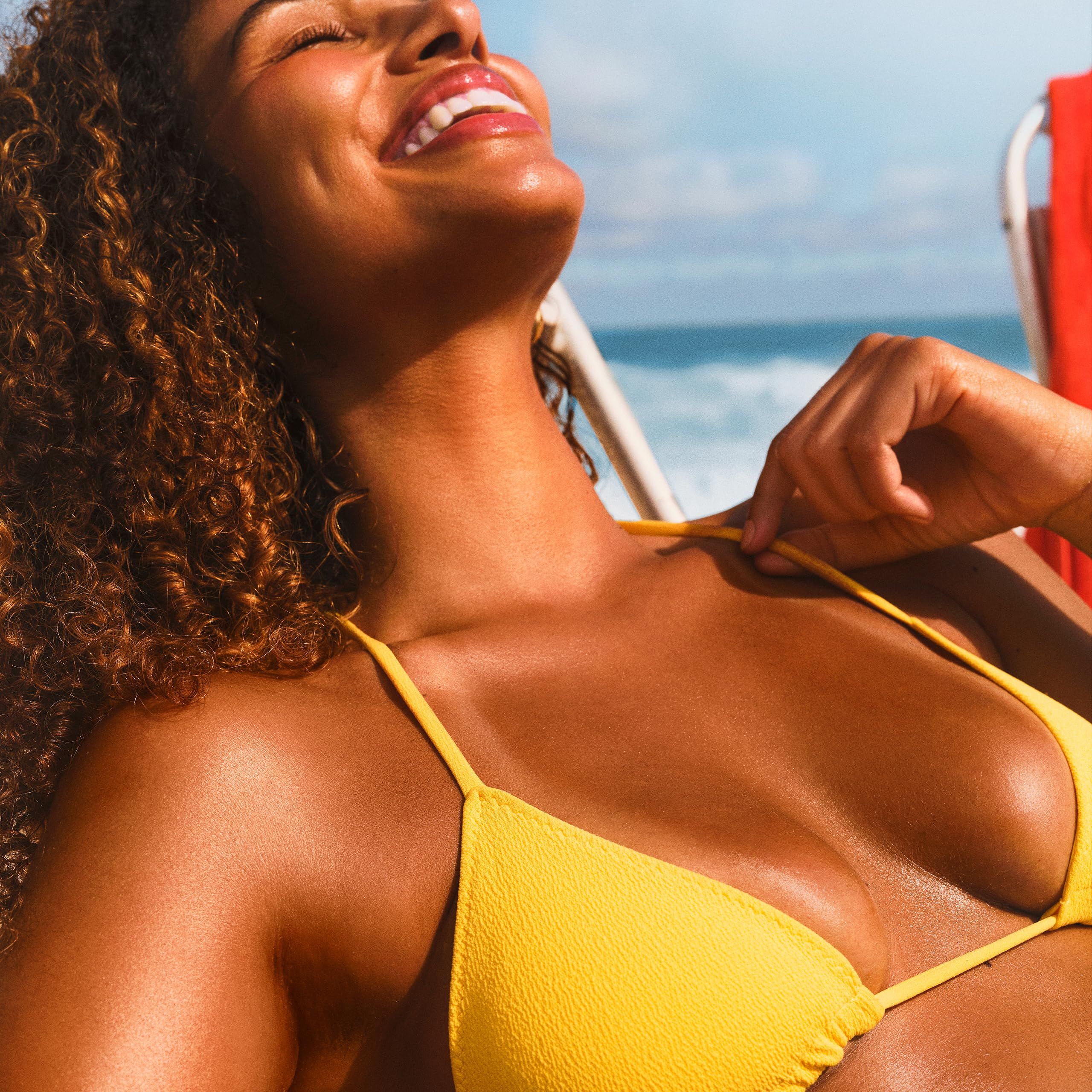 Frau am Strand mit gelbem Bikini. Nahaufnahme. Sonnenschein.