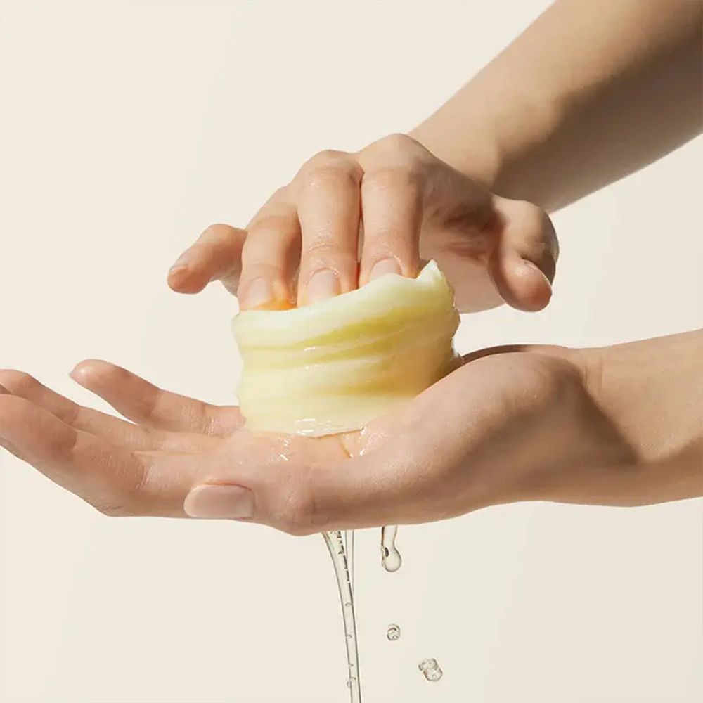 Hand hält ein Medicube Deep Vita C Pad, Serum tropft ab.