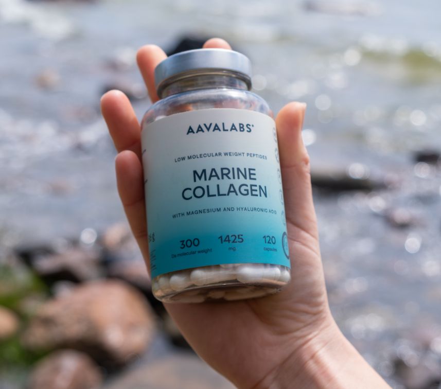 Hand hält eine Flasche Aavalabs Marine Collagen am Wasser.