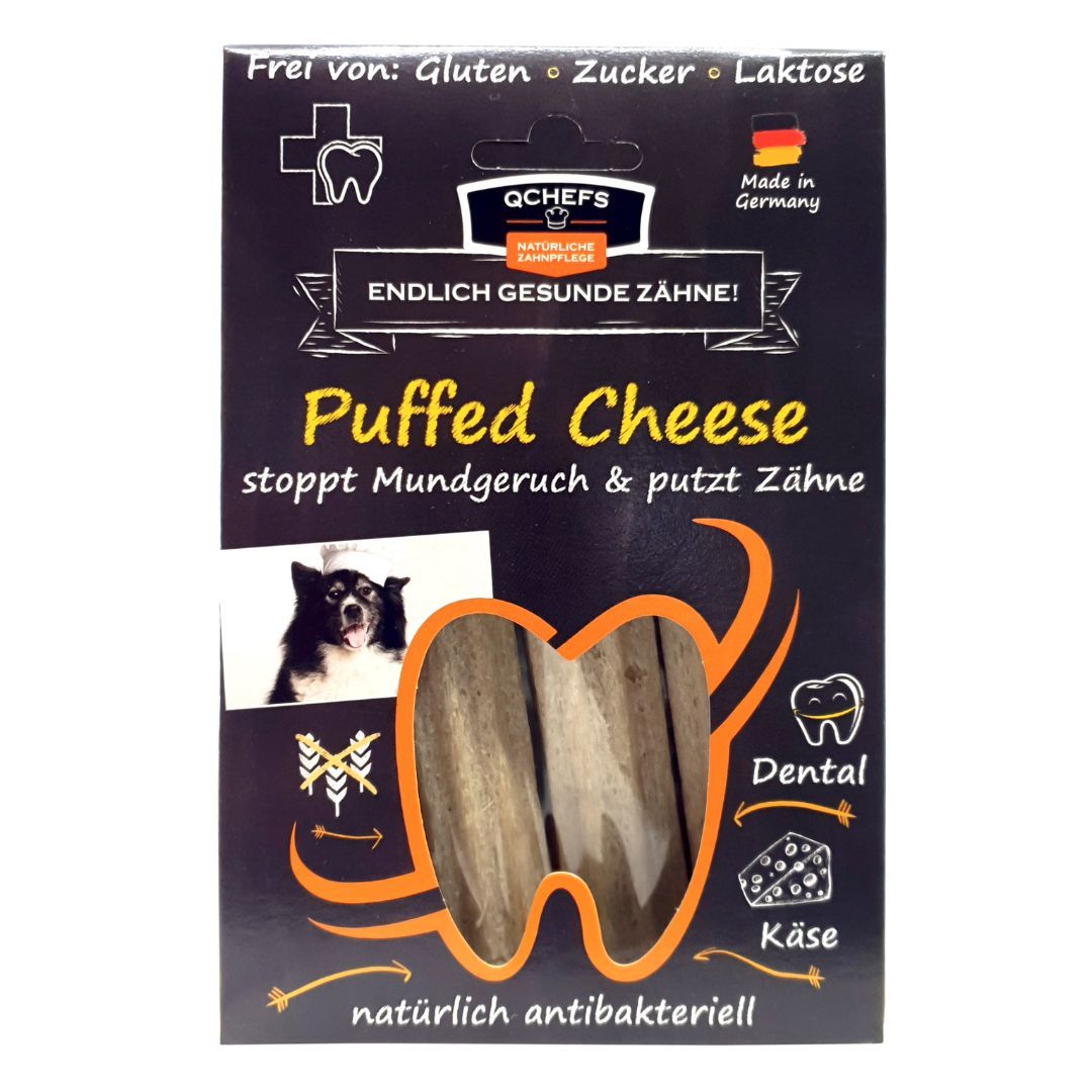 Verpackung mit QCHEFS Puffed Cheese. Text: Frei von Gluten, Zucker, Laktose. Enthält Produktabbildung und Logo.