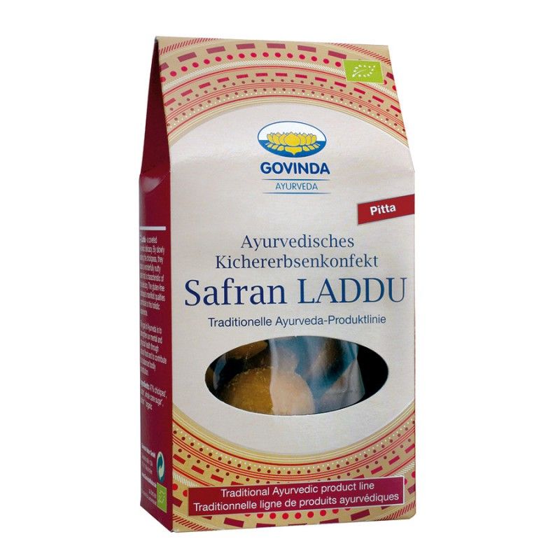 Verpackung mit Safran Laddu. Aufschrift: Govinda Ayurveda, ayurvedisches Kichererbsenkonfekt, Safran Laddu. Bio-Siegel.