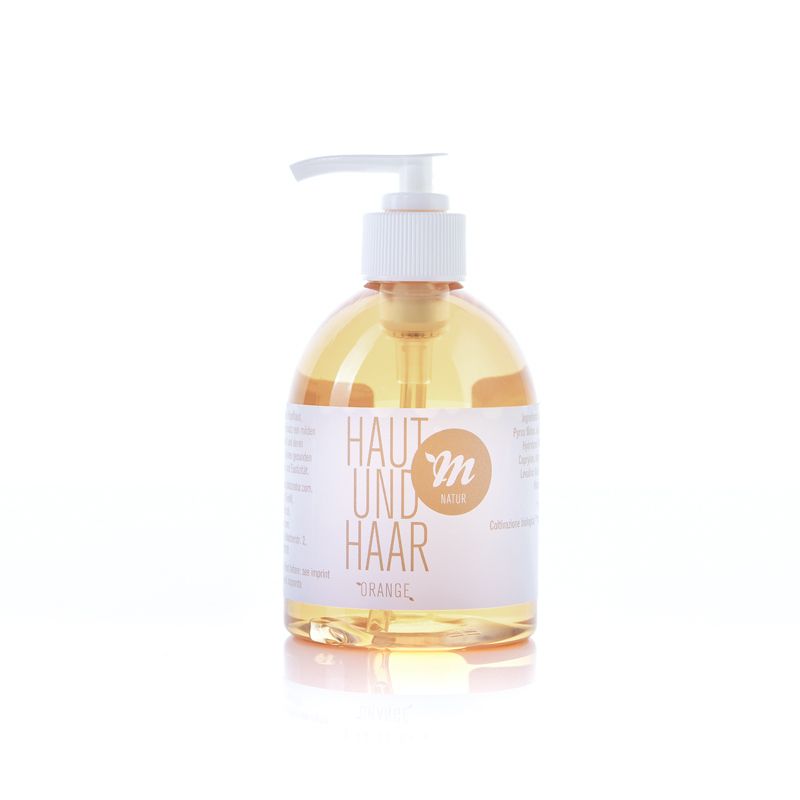 Eine Flasche Uni Sapon Haut und Haar Naturshampoo. Die durchsichtige Flasche enthält eine gelbliche Flüssigkeit. Ein weißer Spenderaufsatz ist oben angebracht. Auf dem Etikett steht "HAUT UND HAAR" und "m natur".
