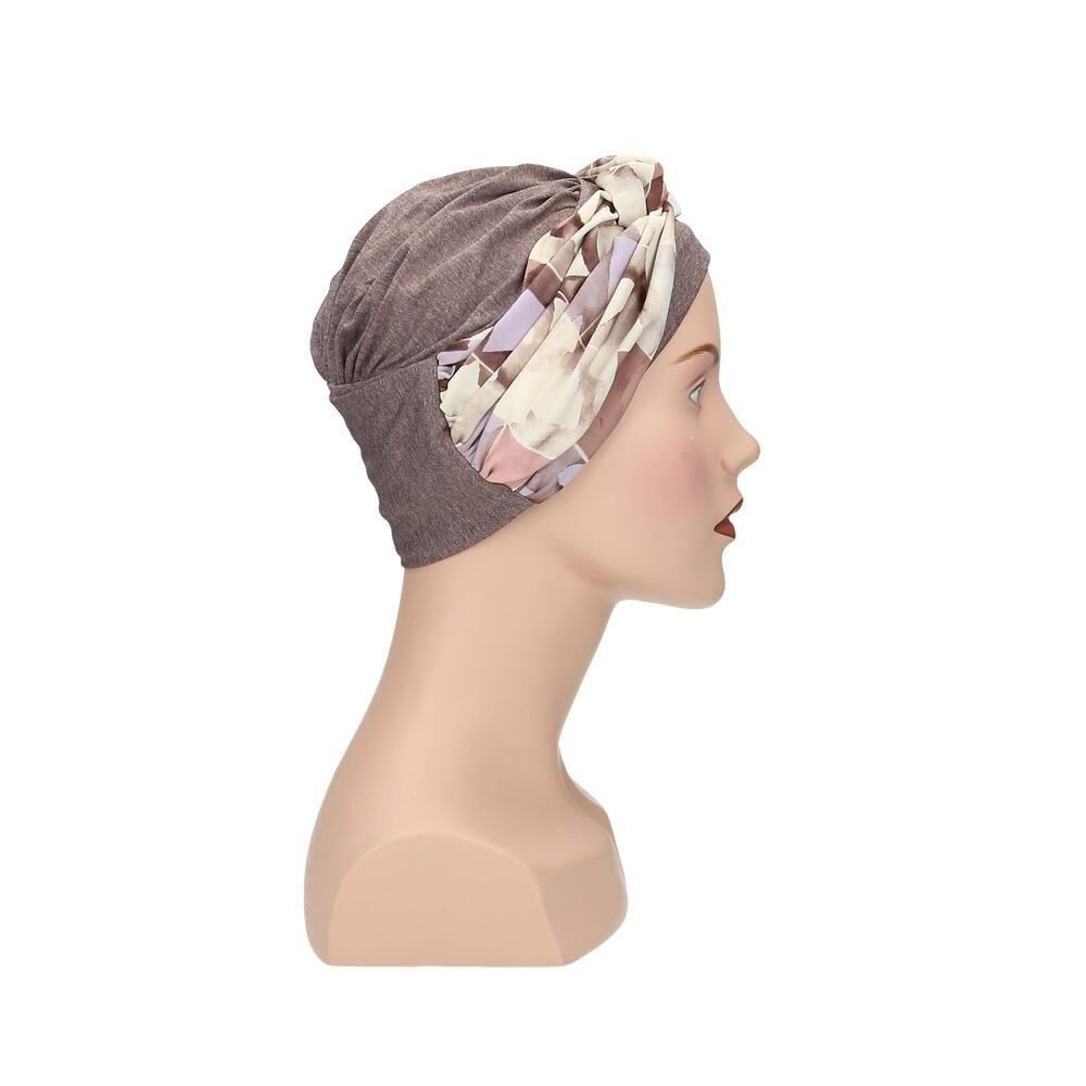 Turban Nora, floral Muster. Grauer Stoff, floraler Überwurf. Auf einer Büste präsentiert.