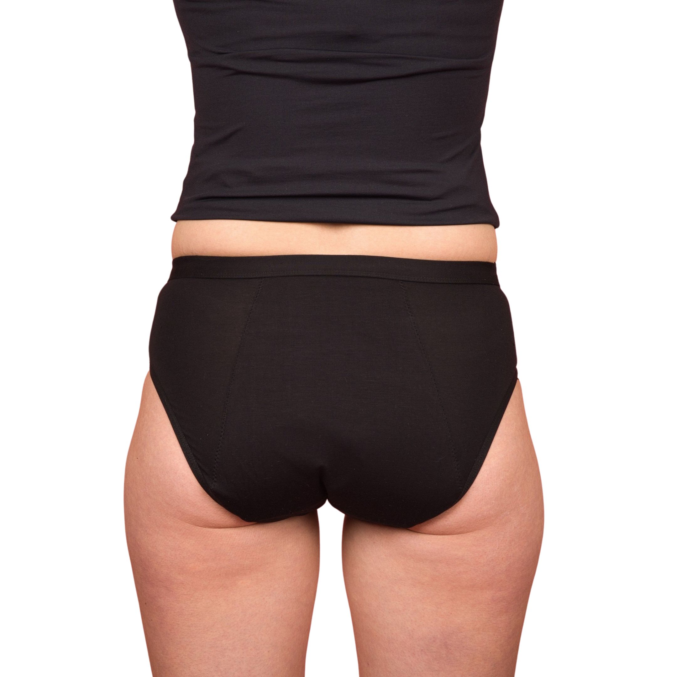 Schwarzer Periodenslip. Rückansicht. Frau trägt schwarzen Tanktop und Slip. Weißer Hintergrund.