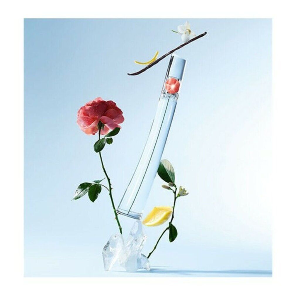 Flacone con fiore, circondato da fiori, limone, vaniglia e ghiaccio. Sfondo blu.