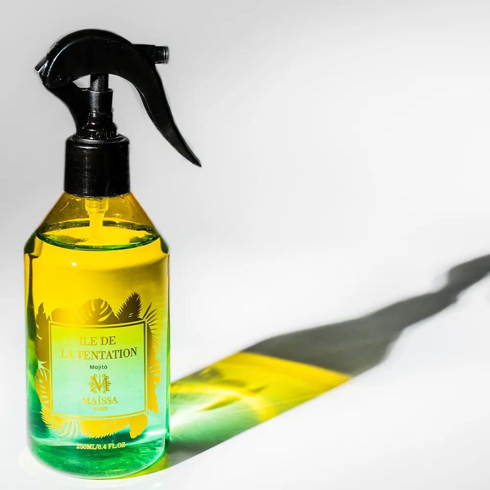 Grüne und gelbe Flüssigkeit in Sprühflasche. Schwarzer Sprühkopf. Aufschrift: ÎLE DE LA TENTATION, MAÏSSA. 125ml/4.4 FL.OZ.