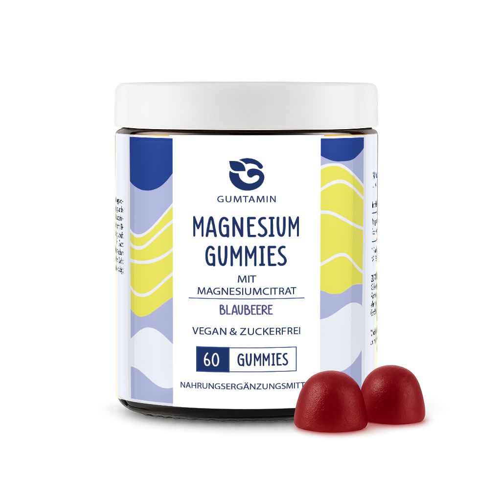 Dose Magnesium Gummibärchen, blaue und weiße Etiketten. Zwei rote Gummibärchen liegen daneben. Text: Gumtamin, Magnesium Gummies, 60 Gummies.