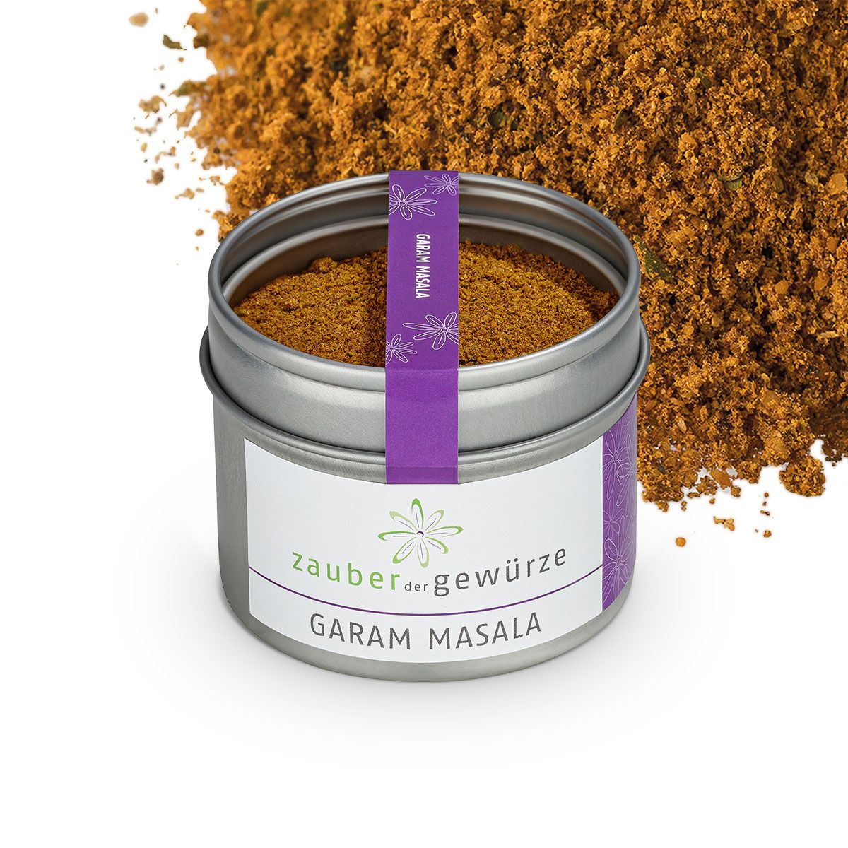 Metallbehälter mit Garam Masala, umgeben von losem Gewürz. Etikett mit 'Zauber der Gewürze' und 'Garam Masala'. Lila Band mit 'Garam Masala'.