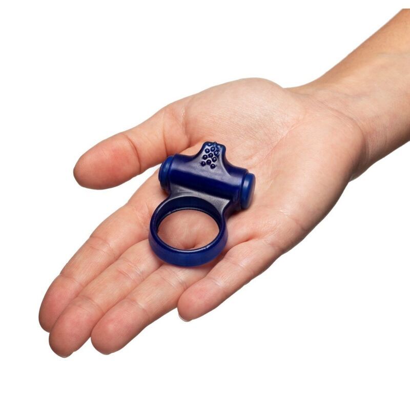 Ein blauer Penisring mit Noppen und einem Riemen liegt in einer Handfläche.