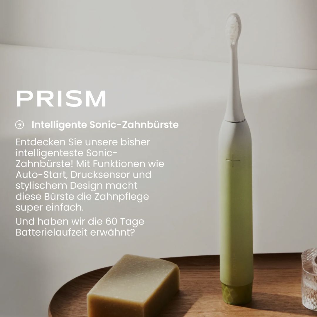 Grüne Be Lucent Prism Sonic Elektrische Zahnbürste auf einem Holztablett neben Seife.