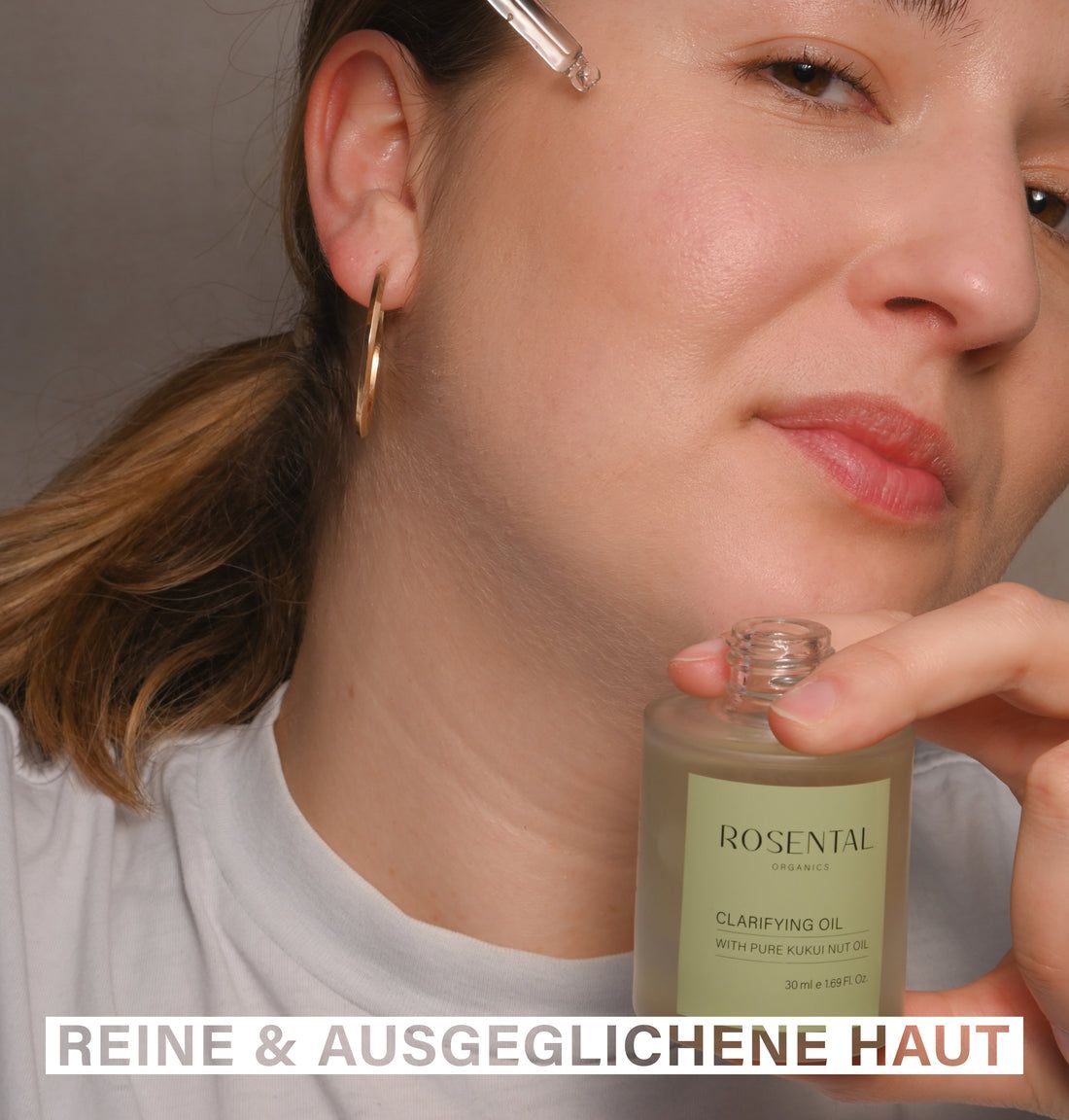 Frau hält eine Flasche Klarifizierendes Öl. Aufschrift: Rosental Organics, Clarifying Oil. Text: Reine & Ausgeglichene Haut.