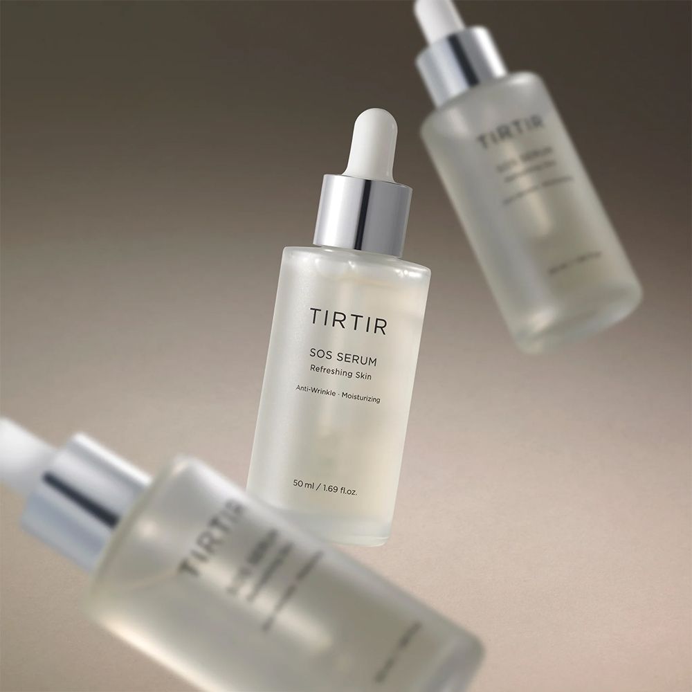 Drei Serumflaschen mit Pipetten. Aufschrift: TIRTIR SOS Serum. 50 ml/1.69 fl.oz. Auf grauem Hintergrund.