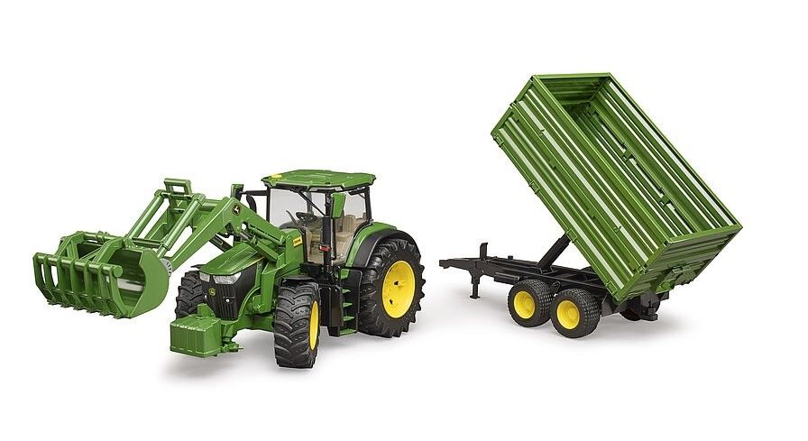 Grüner Traktor mit Frontlader und Anhänger. Gelbe Räder. Anhänger gekippt. Spielzeugmodell.