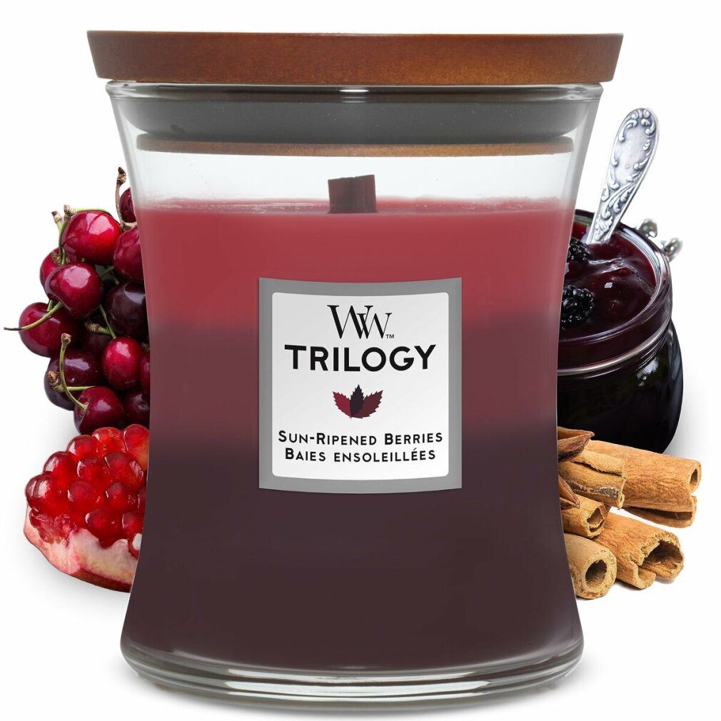 Kerze im Glas mit Holzdeckel. Label 'WW Trilogy Sun-Ripened Berries'. Zusätzliche Früchte und Zimtstangen.