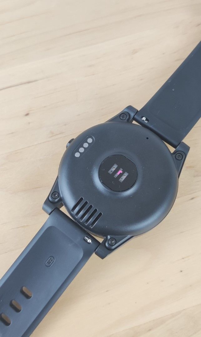 Rückseite einer schwarzen Smartwatch mit Ladekontakten und Herzfrequenzsensor.