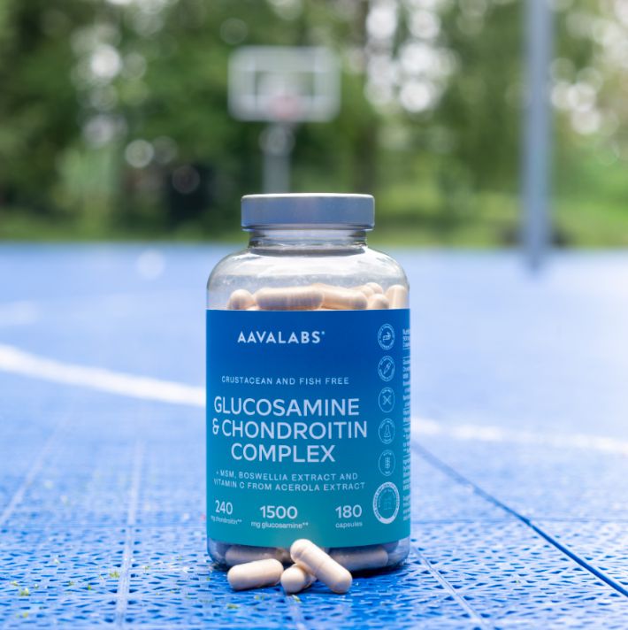 Flasche mit Glucosamin-Kapseln auf einem Sportplatz.
